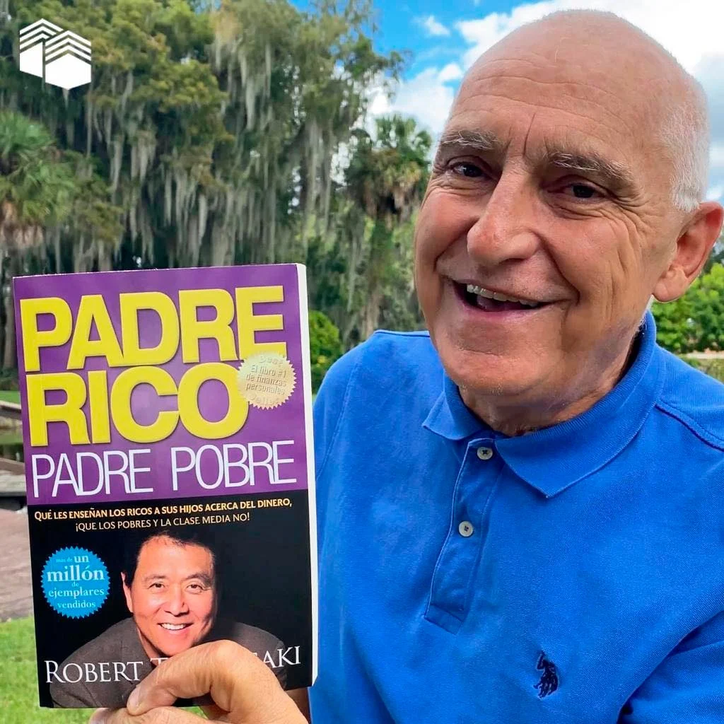 carlos sosteniendo libro padre rico padre pobre